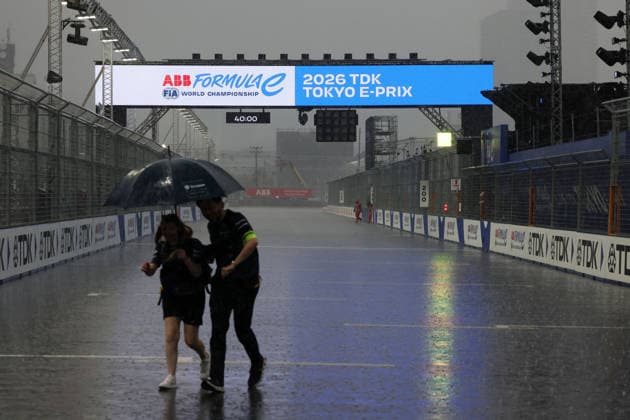 Zwei FE Teammitglieder laufen über die Start- Zielgeraden, wegen Gewitter das Fahrerlager, FIA Formel E Weltmeisterschaft, Saison 12, Tokio E- Prix, 26.07.2026, Evakuierung *** Two FE team members run across the start-finish straight; the paddock is evacuated due to a thunderstorm; FIA Formula E World Championship, Season 12, Tokyo E-Prix, July 26, 2026; evacuation