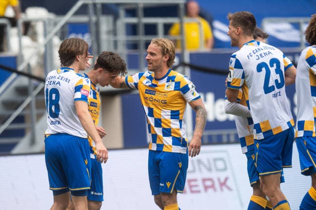 Regionalliga Nordost 2026 27, 1. Spieltag am 26.07.2026 FC Carl Zeiss Jena vs FSV Zwickau Mitte: Jena Kapitän Nils Butzen beglückwünscht Mitspieler Emilio Munser zu seinem Tor zum 1:0 für Jena ad hoc Arena im Ernst-Abbe *** Northeast Regional League 2026-27, Matchday 1 on July 26, 2026: FC Carl Zeiss Jena vs. FSV Zwickau Mitte. Jena captain Nils Butzen congratulates teammate Emilio Munser on his goal to make it 1–0 for Jena at the ad hoc Arena at Ernst Abbe Sport.