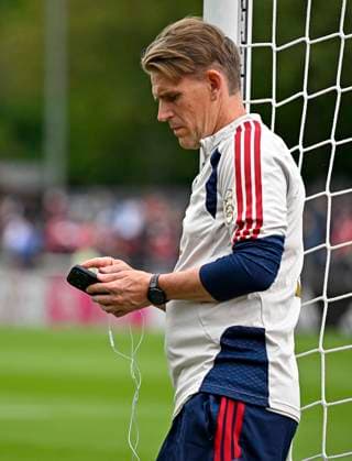 27.07.2026, Fussball Bundesliga 2026 2027, Trainingslager FC Bayern München in Rottach-Egern am Tegernsee (Bayern). Sportdirektor Christoph Freund (Bayern München) lehnt sich am Torpfosten an und ist am Handy. *** July 27, 2026, 2026–2027 Bundesliga, FC Bayern Munich training camp in Rottach Egern on Lake Tegernsee; Bayern sporting director Christoph Freund is leaning against the goalpost and talking on his cell phone