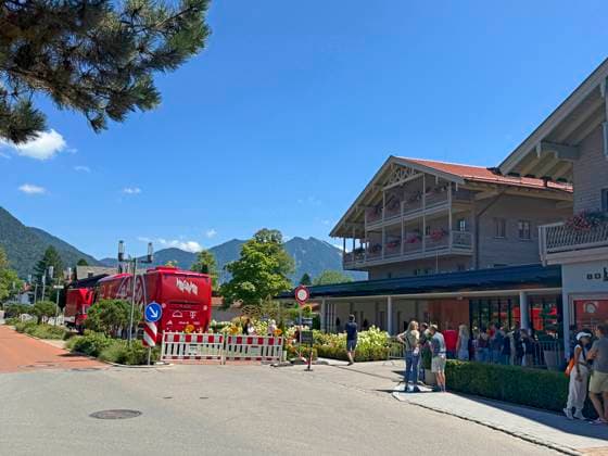 28.07.2026, Fussball Bundesliga 2026 2027, Trainingslager FC Bayern München in Rottach-Egern am Tegernsee (Bayern). Am Mannschaftshotel Parkhotel Egerner Höfe wurde eine Spur gesperrt für den parkenden Bayern-Mannschaftsbus, inklusive temporär aufgestellter Verkehrsampel. Bayernfans warten vor dem Hotel auf Autogramme ihrer Stars. *** July 28, 2026, 2026–2027 Bundesliga Season, FC Bayern Munich training camp in Rottach Egern on Lake Tegernsee, Bavaria. At the team hotel, Parkhotel Egerner Höfe, a lane was closed to accommodate the parked Bayern team bus, including a temporarily installed traffic light. Bayern fans wait in front of the hotel for autographs from their stars.