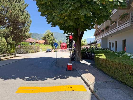 28.07.2026, Fussball Bundesliga 2026 2027, Trainingslager FC Bayern München in Rottach-Egern am Tegernsee (Bayern). Am Mannschaftshotel Parkhotel Egerner Höfe wurde eine Spur gesperrt für den parkenden Bayern-Mannschaftsbus, inklusive temporär aufgestellter Verkehrsampel. *** July 28, 2026, 2026–2027 Bundesliga season, FC Bayern Munich training camp in Rottach-Egern on Lake Tegernsee, Bavaria. At the team hotel, Parkhotel Egerner Höfe, a lane was closed to accommodate the parked Bayern team bus, including a temporarily installed traffic light.