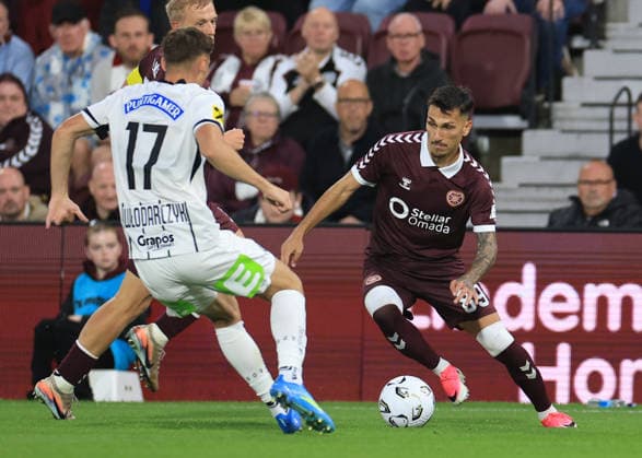 Heart of Midlothian v SK Sturm Graz UEFA Champions League Alexandros Kyziridis of Heart of Midlothian (right) cuts inside Szymon Wlodarczyk of SK Sturm Graz during the UEFA Champions League Second Qualifying Round Second Leg match at Tynecastle Park, Edinburgh 28 07 2026 UK Newspapers OUT Copyright: xFredxPalmerx FIL-23686-0129