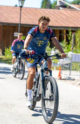 28.07.2026, Fussball Bundesliga 2026 2027, Trainingslager FC Bayern München in Rottach-Egern am Tegernsee (Bayern). Die Spieler fahren mit Fahrrädern zum Trainingsplatz, hier Tom Bischof (FC Bayern München) *** July 28, 2026, 2026–2027 Bundesliga, FC Bayern Munich training camp in Rottach Egern on Lake Tegernsee, Bavaria. The players ride bicycles to the training field; pictured here is Tom Bischof of FC Bayern Munich
