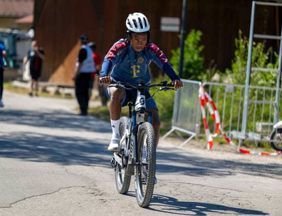 28.07.2026, Fussball Bundesliga 2026 2027, Trainingslager FC Bayern München in Rottach-Egern am Tegernsee (Bayern). Die Spieler fahren mit Fahrrädern zum Trainingsplatz, hier Wisdom Mike (FC Bayern München) *** July 28, 2026, 2026–2027 Bundesliga, FC Bayern Munich training camp in Rottach-Egern on Lake Tegernsee, Bavaria. The players ride bicycles to the training field; here is Wisdom Mike of FC Bayern Munich.
