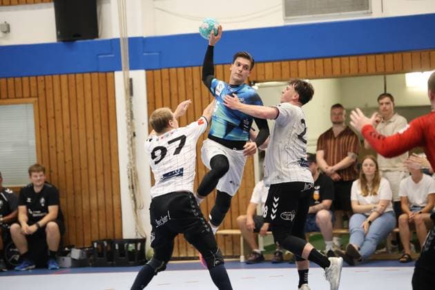 Domen Makuc springt hoch und zieht zum Wurf ab, während zwei Spieler der HSG Eider Harde versuchen, den Abschluss zu blocken. Der Ball ist klar im Bild, die Szene zeigt den Höhepunkt der Wurfaktion in der Werner-Kuhrt-Halle in Hohn. Domen Makuc im Sprungwurf gegen die Abwehr der HSG Eider Harde *** Domen Makuc jumps high and releases the shot, while two HSG Eider Harde players try to block it. The ball is clearly visible in the frame; the scene captures the climax of the shot at the Werner Kuhrt Halle in Hohn. Domen Makuc takes a jump shot against the HSG Eider Harde defense. Copyright: xspeedshotx
