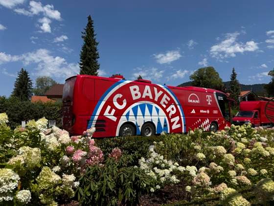 RECORD DATE NOT STATED 30.07.2026, Fussball Bundesliga 2026 2027, Trainingslager FC Bayern München in Rottach-Egern am Tegernsee (Bayern). Testspiel FC Rottach Egern - FC Bayern München, Der Mannschaftsbus des FC Bayern München steht am Hotel vor dem Eingang, vor einem herrlichen Blumenbeet. *** July 30, 2026, 2026–2027 Bundesliga Season, FC Bayern Munich Training Camp in Rottach Egern on Lake Tegernsee, Bavaria: Friendly Match between FC Rottach Egern and FC Bayern Munich, The FC Bayern Munich team bus is parked in front of the hotel entrance, in front of a beautiful flower bed