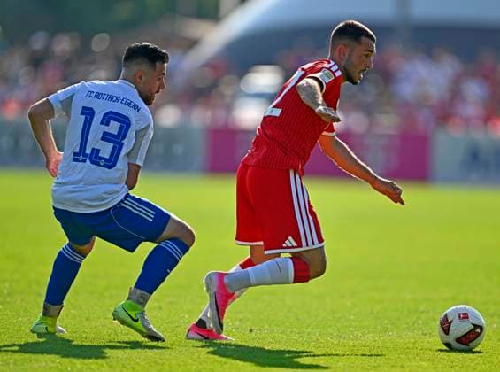 30.07.2026, Fussball Bundesliga 2026 2027, Trainingslager FC Bayern München in Rottach-Egern am Tegernsee (Bayern). Testspiel FC Rottach Egern - FC Bayern München, Ferhat Yilmazer (Rottach Egern) gegen Arijon Ibrahimovic (FC Bayern München). *** July 30, 2026, 2026–2027 Bundesliga, FC Bayern Munich training camp in Rottach Egern on Lake Tegernsee, Bavaria; friendly match between FC Rottach Egern and FC Bayern Munich; Ferhat Yilmazer (Rottach Egern) vs. Arijon Ibrahimovic (FC Bayern Munich)