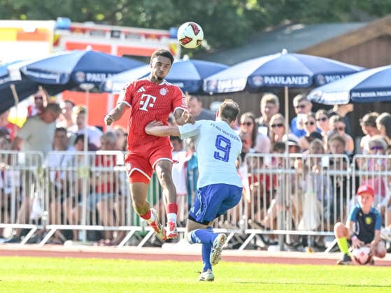 Rottach - Egern, Deutschland, 30.07.26: Vincent Manuba (FC Bayern München) und Torwart Kilian Zimmer (FC Rottach-Egern) im Zweikampf waehrend des Friedly Match Spiels zwischen dem FC Rottach - Egern vs FC Bayern München im Stadion am Birkenmoos am 30. Juli 2026 in Rottach - Egern, Deutschland. (Foto von Harry Langer DeFodi Images) Rottach - Egern, Germany, 30.07.26: Vincent Manuba (FC Bayern München) und Torwart Kilian Zimmer (FC Rottach-Egern) battle for the ball during the Friedly Match match between FC Rottach - Egern vs FC Bayern München at Stadion am Birkenmoos on July 30, 2026 in Rottach - Egern, Germany. (Photo by Harry Langer DeFodi Images) DFB DFL REGULATIONS PROHIBIT ANY USE OF PHOTOGRAPHS AS IMAGE SEQUENCES AND OR QUASI-VIDEO. (Photo by Harry Langer DeFodi Images) DFB DFL REGULATIONS PROHIBIT ANY USE OF PHOTOGRAPHS AS IMAGE SEQUENCES AND OR QUASI-VIDEO. - *** Rottach Egern, Germany, July 30, 2026: Vincent Manuba of FC Bayern Munich and goalkeeper Kilian Zimmer of FC Rottach Egern go head-to-head during the friendly match between FC Rottach Egern and FC Bayern Munich at the Stadion am Birkenmoos on July 30, 2026, in Rottach Egern, Germany. Photo by Harry Langer, DeFodi Images. Rottach Egern, Germany, July 30, 2026: Vincent Manuba of FC Bayern Munich and goalkeeper Kilian Zimmer of FC Rottach Egern battle for the ball during the friendly match between FC Rottach Egern and FC Bayern Munich at Stadion am Birkenmoos on July 30, 2026, in Rottach Egern, Germany Photo by Harry Langer, DeFodi Images. DFB and DFL regulations prohibit any use of photographs as image sequences and or quasi-video. Photo by Harry Langer, DeFodi Images. DFB and DFL regulations prohibit any use of photographs as imSEQUENCES AND OR QUASI-VIDEO