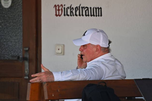 Uli HOENESS (Höness,Ehrenpraesident Bayern Muenchen) sitzt und telefoniert vor dem Wickelraum, Einzelbild,angeschnittenes Einzelmotiv,Halbfigur,halbe Figur. Testspiel FC Rottach Egern - FC Bayern Muenchen Trainingslager in Rottach Egern am 30.07.2026. Fussball 1. Bundesliga,Saison 2026 2027. *** Uli HOENESS Höness,Honorary President of Bayern Munich, sitting and talking on the phone in front of the changing room; single frame, cropped image, half-length portrait; friendly match between FC Rottach Egern and FC Bayern Munich at the training camp in Rottach Egern on July 30, 2026; soccer, Bundesliga 1,2026–2027 season