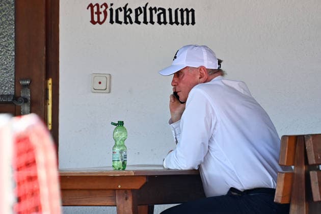 Uli HOENESS (Höness,Ehrenpraesident Bayern Muenchen) sitzt und telefoniert vor dem Wickelraum, Einzelbild,angeschnittenes Einzelmotiv,Halbfigur,halbe Figur. Testspiel FC Rottach Egern - FC Bayern Muenchen Trainingslager in Rottach Egern am 30.07.2026. Fussball 1. Bundesliga,Saison 2026 2027. *** Uli HOENESS Höness,Honorary President of Bayern Munich, sitting and talking on the phone in front of the changing room; single frame, cropped image, half-length portrait; friendly match between FC Rottach Egern and FC Bayern Munich at the training camp in Rottach Egern on July 30, 2026; soccer, Bundesliga 1,2026–2027 season
