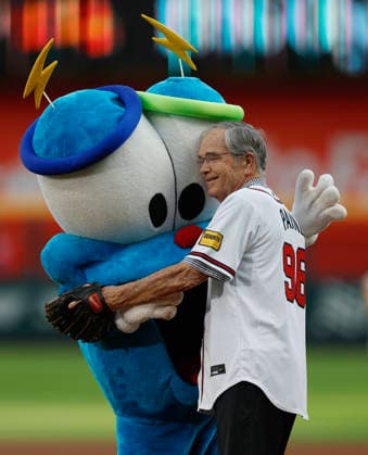 1996 Atlanta Committee for the Olympic Games, Olympische Spiele, Olympia, OS President Billy Payne (right) hugs Atlanta Olympic Games mascot Izzy before Payne threw out the ceremonial first pitch before the game between the Washington Nationals and the Atlanta Braves at Truist Park on Friday, July 31, 2026 in Atlanta, Georgia.  ATL20260731111 MikexZarrilli
