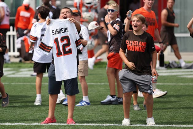 Young Cleveland Browns fans attempt to get the attention of Shedeur Sanders (2) for autographs after training camp in Berea, Ohio on Friday July 31, 2026.  CLE20260731103 AARONxJOSEFCZYK