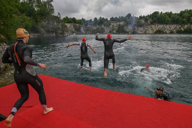 TRIATHLON: Stepniak And Bartlett Secure Elite Victories At IRONMAN 70.3 Krakow KRAKOW, POLAND - AUGUST 02: Triathletes from the first amateur starting wave leap from a floating pontoon ramp as a photographer diver monitors the course during the swim stage launch of the Enea IRONMAN 70.3 Krakow triathlon at the Zakrzowek Reservoir in Krakow, Lesser Poland Voivodeship, Poland, on August 02, 2026. Nearly 3,800 registered athletes across all weekend events, including over 2,100 for the main 113-kilometer (70.3-mile) distance, kicked off the competition inside the flooded limestone quarry under strict safety supervision. Krakow Poland  Copyright: xArturxWidakx originalFilename:widak-triathlo260802_npY4L.jpg