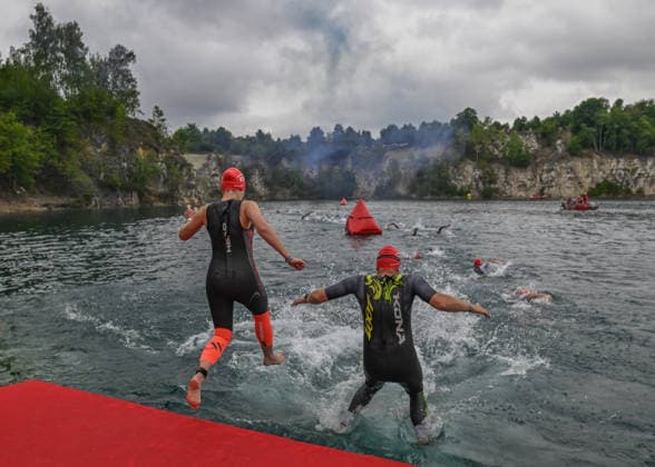 TRIATHLON: Stepniak And Bartlett Secure Elite Victories At IRONMAN 70.3 Krakow KRAKOW, POLAND - AUGUST 02: Triathletes from an amateur starting wave leap from a floating pontoon ramp during the swim stage launch of the Enea IRONMAN 70.3 Krakow triathlon at the Zakrzowek Reservoir in Krakow, Lesser Poland Voivodeship, Poland, on August 02, 2026. Nearly 3,800 registered athletes across all weekend events, including over 2,100 for the main 113-kilometer (70.3-mile) distance, kicked off the competition inside the flooded limestone quarry before transitioning to the cycling and running phases. Krakow Poland  Copyright: xArturxWidakx originalFilename:widak-triathlo260802_npFIt.jpg