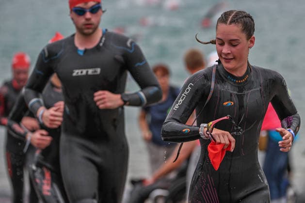 TRIATHLON: Stepniak And Bartlett Secure Elite Victories At IRONMAN 70.3 Krakow KRAKOW, POLAND - AUGUST 02: A female triathlete checks her smartwatch while running up the exit ramp during the swim-to-bike transition stage of the Enea IRONMAN 70.3 Krakow triathlon at the Zakrzowek Reservoir in Krakow, Lesser Poland Voivodeship, Poland, on August 02, 2026. Following the morning swim leg inside the flooded limestone quarry, over 2,100 registered competitors completed their 1.9-kilometer open-water course before heading toward the Transition 1 (T1) zone to begin the 90-kilometer cycling discipline. Krakow Poland  Copyright: xArturxWidakx originalFilename:widak-triathlo260802_npJyL.jpg