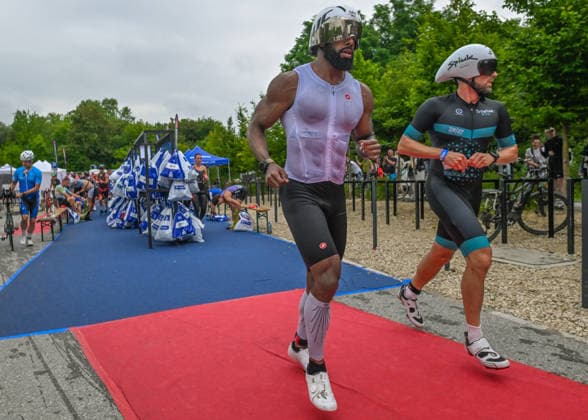 TRIATHLON: Stepniak And Bartlett Secure Elite Victories At IRONMAN 70.3 Krakow KRAKOW, POLAND - AUGUST 02: Age-group triathletes sprint down a red carpet in their cycling shoes while wearing aerodynamic helmets inside the Transition 1 (T1) zone during the Enea IRONMAN 70.3 Krakow triathlon in Krakow, Lesser Poland Voivodeship, Poland, on August 02, 2026. Following the opening 1.9-kilometer open-water swim phase inside the Zakrzowek Reservoir, over 2,100 registered competitors rushed through the designated change area to mount their bicycles and begin the 90-kilometer cycling segment. Krakow Poland  Copyright: xArturxWidakx originalFilename:widak-triathlo260802_npbRd.jpg