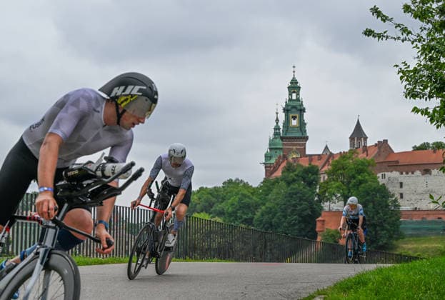 TRIATHLON: Stepniak And Bartlett Secure Elite Victories At IRONMAN 70.3 Krakow KRAKOW, POLAND - AUGUST 02: Ttriathletes focus on the road as they navigate a sharp descent on their time-trial bicycles past the historic Wawel Royal Castle during the 90-kilometer cycling segment of the Enea IRONMAN 70.3 Krakow triathlon in Krakow, Lesser Poland Voivodeship, Poland, on August 02, 2026. A field of over 2,100 registered competitors executed a high-speed bike course winding past the city s historic landmarks before transitioning to the final half-marathon run. Krakow Poland  Copyright: xArturxWidakx originalFilename:widak-triathlo260802_npTQI.jpg