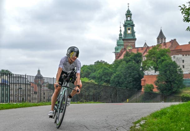 TRIATHLON: Stepniak And Bartlett Secure Elite Victories At IRONMAN 70.3 Krakow KRAKOW, POLAND - AUGUST 02: A triathlete navigates a curve on her time-trial bicycle with the historic Wawel Royal Castle rising in the background during the 90-kilometer cycling segment of the Enea IRONMAN 70.3 Krakow triathlon in Krakow, Lesser Poland Voivodeship, Poland, on August 02, 2026. A field of over 2,100 registered competitors executed the high-speed bike course winding past the city s historic landmarks before transitioning into the final run discipline. Krakow Poland  Copyright: xArturxWidakx originalFilename:widak-triathlo260802_npJKr.jpg