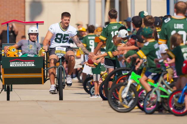 Green Bay Packers Training Camp 2026 Tucker Kraft 85 of the Green Bay Packers rides a bicycle and high-fives fans while participating in the Dream Drive at Ray Nitschke Field in Ashwaubenon, Wisconsin, on August 2, 2026. Ashwaubenon Wisconsin United States  Copyright: xRossxHarriedx originalFilename:harried-greenbay260802_npkUJ.jpg