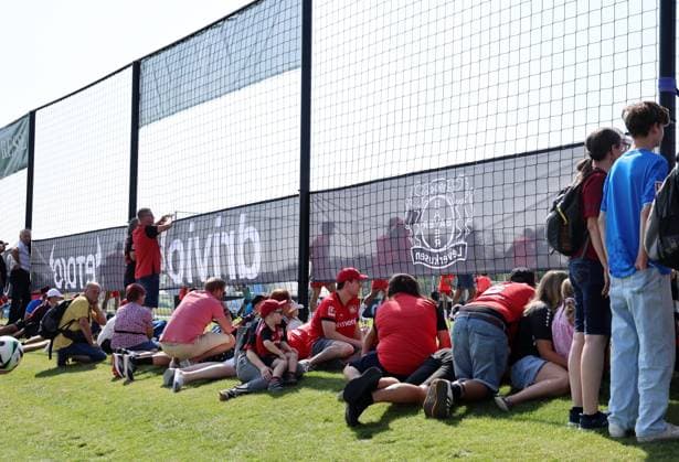 GER, Trainingslager Bayer 04 Leverkusen - Blankenhain 03.08.2026, Blankenhain, GER, Saison 2026 2027, 1.Bundesliga, Bayer 04 Leverkusen - Trainingslager im Bild Fans verfolgen den Trainingsbeginn durch ein Netz DFL regulations prohibit any use of photographs as image sequences and or quasi-video *** GER, Bayer 04 Leverkusen Training Camp in Blankenhain, August 3, 2026, Blankenhain, GER, 2026–2027 Season, Bundesliga 1, Bayer 04 Leverkusen Training Camp in Pictures: Fans watch the start of training through a net. DFL regulations prohibit any use of photographs as image sequences and or quasi-video.