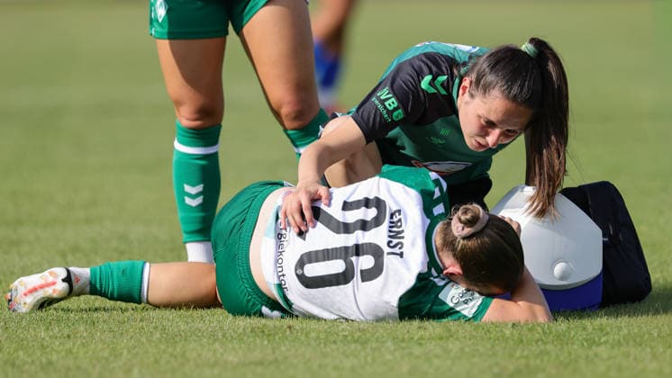 v.li.: Sarah Ernst (SV Werder Bremen, 26) wird verletzt von Nina Pöhlmann (Physiotherapeutin, SV Werder Bremen) behandelt, liegt verletzt am Boden, Verletzung, Schmerzen, schmerzverzerrtes Gesicht, 04.08.2026, Herzlake (Deutschland), Fussball, Testspiel Frauen, SV Werder Bremen - AZ Alkmaar *** From left: Sarah Ernst of SV Werder Bremen, 26, is being treated for an injury by Nina Pöhlmann, a physical therapist at SV Werder Bremen; she is lying on the ground injured; injury, pain, a face contorted with pain, August 4, 2026, Herzlake, Germany, soccer, women’s friendly match, SV Werder Bremen vs. AZ Alkmaar xobx