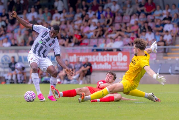 Memmingen, Deutschland 03. August 2026: Toto-Pokal - Bayerischer Landespokal - 2026 2027 - 2. Hauptrunde - FC Memmingen gegen FC Ingolstadt 04 Im Bild: v. li. im Zweikampf Obed Ugondu (FCI) und Torhüter Dominik Dewein (FCM) e-con ArenaPark Bayern *** Memmingen, Germany, August 3, 2026, Toto Cup, Bavarian State Cup 2026–2027, Round 2, FC Memmingen vs. FC Ingolstadt 04. Pictured from left: Obed Ugondu (FCI) and goalkeeper Dominik Dewein (FCM) in a tackle at ArenaPark Bavaria Copyright: xFotostandx xSchäferx