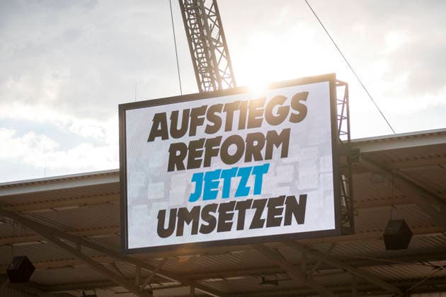 GER, Erfurt, Fussball, Regionalliga Nordost, 3. Spieltag, FC Rot-Weiss Erfurt vs. Tasmania Berlin im Bild v.l.: Aufstiegsreform Jetzt Umsetzen auf der Videowand, der Ball ruhte in der ersten Spielminute, Protest, dazu Ansage im Stadion 05.08.2026, Steigerwaldstadion Erfurt DFB REGULATIONS PROHIBIT ANY USE OF PHOTOGRAPHS AS IMAGE SEQUENCES AND OR QUASI-VIDEO, *** GER, Erfurt, Soccer, Northeast Regional League, Matchday 3, FC Rot Weiss Erfurt vs. Tasmania Berlin: In the picture, from left, Promotion Reform—Implement Now displayed on the video wall; the ball was at rest in the first minute of the game; protest; plus an announcement in the stadium on August 5, 2026, Steigerwaldstadion, Erfurt. DFB regulations prohibit any use of photographs as image sequences and or quasi-video, Copyright: HMBxMedia PaulxFritz