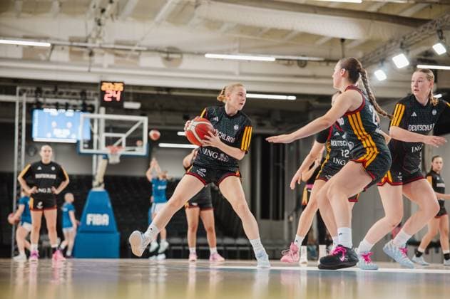 RECORD DATE NOT STATED Eine Spielerin des deutschen Nationalteams hält den Basketball und sucht eine Anspielstation, während drei Mitspielerinnen in Bewegung sind. Im Hintergrund ist das FIBA-Spielfeld mit Anzeigetafel und Korb zu sehen. Deutschland-Spielerin mit Ball im Angriff gegen Gegnerinnen *** A player on the German national team is holding the basketball and looking for a teammate to pass to, while three of her teammates are on the move. In the background, the FIBA court is visible, complete with a scoreboard and a basket. A German player with the ball is on the offensive against her opponents. Copyright: xJoelxKruehlerx