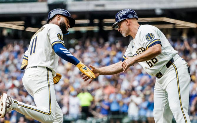 Milwaukee Brewers left fielder Jackson Chourio (L) celebrates with Milwaukee Brewers third base coach Matt Erickson (R) after hitting a home run in the first inning of the MLB, Baseball Herren, USA game between the Pittsburgh Pirates and the Milwaukee Brewers at American Family Field in Milwaukee, Wisconsin on Thursday, August 6, 2026.  MIL20260806807 TANNENxMAURY