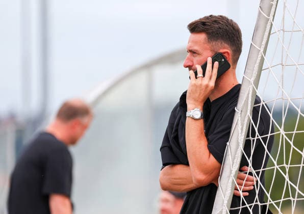 07.08.2026, Deutschland, Grassau, Fußball Bundesliga, Saison 2026 2027, Trainingslager VfB Stuttgart, Sportdirektor Christian Gentner am Telefon, Handy *** August 7, 2026, Germany, Grassau, Bundesliga, 2026–2027 season, VfB Stuttgart training camp, sporting director Christian Gentner on the phone, cell phone
