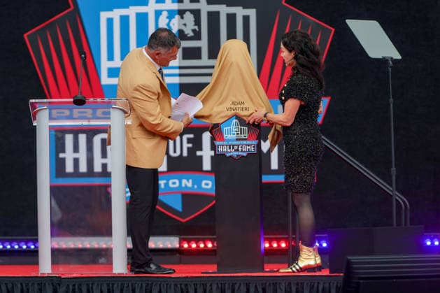 August 8, 2026: Adam Vinatieri, along with Colt co-owner and CEO Carlie Irsay-Gordon, uncover his Hall of Fame bust during the NFL, American Football Herren, USA Hall of Fame Enshrinement Ceremony at the Tom Benson Hall of Fame Stadium in Canton, OH. CSM Canton USA - ZUMAc04_ 20260808_zma_c04_226 Copyright: xJonathanxMailhesx