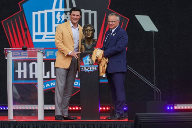 NFL, American Football Herren, USA 2026: NFL Hall Of Fame Enshrinement Ceremony AUG 08 August 8, 2026: Luke Kuechly, along with his father Tom Kuechly, pose for a picture with his Hall of Fame bust during the NFL Hall of Fame Enshrinement Ceremony at the Tom Benson Hall of Fame Stadium in Canton, OH. Jonathan Mailhes CSM (Credit Image: Â Jonathan Mailhes Cal Media) Canton Oh USA EDITORIAL USE ONLY Copyright: xx ZUMA-20260808_zma_c04_231.jpg JonathanxMailhesx csmphotothree509718