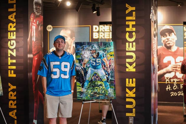 NFL, American Football Herren, USA 2026: NFL Hall Of Fame Enshrinement Ceremony AUG 08 August 8, 2026: A fan of the Carolina Panthers take a picture with the Luke Kuechly exhibit in the Hall of Fame prior to the NFL Hall of Fame Enshrinement Ceremony at the Tom Benson Hall of Fame Stadium in Canton, OH. Jonathan Mailhes CSM (Credit Image: Â Jonathan Mailhes Cal Media) Canton Oh USA EDITORIAL USE ONLY Copyright: xx ZUMA-20260808_zma_c04_207.jpg JonathanxMailhesx csmphotothree509742