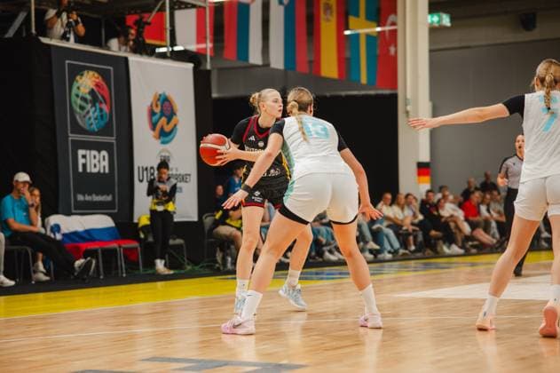 RECORD DATE NOT STATED Eine Spielerin Deutschlands hält den Ball und sucht nach einer Anspielstation, während eine Gegenspielerin Slovenijas mit der Nummer 13 sie eng verteidigt. Im Hintergrund sind Länderflaggen und FIBA U18-Branding zu sehen. Deutschland-Spielerin im Ballbesitz gegen Slovenija-Verteidigung *** A German player has the ball and is looking for a teammate to pass to, while a Slovenian opponent wearing number 13 is guarding her closely. National flags and FIBA U18 branding can be seen in the background. A German player has the ball against the Slovenian defense. Copyright: xJoelxKruehlerx