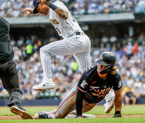 Milwaukee Brewers third baseman Joey Ortiz jumps over Minnesota Twins right fielder Luke Keaschall after tagging him out on a steal attempt in the third inning of the MLB, Baseball Herren, USA game between the Minnesota Twins and the Milwaukee Brewers at American Family Field in Milwaukee, Wisconsin on Saturday, August 8, 2026.  MIL20260808819 TANNENxMAURY