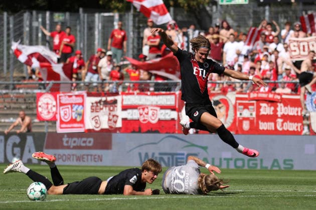 08.08.2026, xsefx, Fußball, FC Viktoria Köln SSV Jahn Regensburg, 3.Liga, Sportpark Höhenberg, 1. Spieltag, Saison 2026 2027: Tobias Eisenhuth (FC Viktoria Koeln 06) springt über den am Boden liegenden John Posselt (Jahn Regensburg 20) DFB regulations prohibit any use of photographs as image sequences and or quasi-video. Nordrhein-Westfalen Deutschland *** August 8, 2026, xsefx, Soccer, FC Viktoria Köln vs. SSV Jahn Regensburg, 3. Liga, Sportpark Höhenberg, Matchday 1, 2026–2027 Season: Tobias Eisenhuth of FC Viktoria Köln 06 jumps over John Posselt of Jahn Regensburg, who is lying on the ground. DFB regulations prohibit any use of photographs as image sequences and or quasi-video. North Rhine-Westphalia, Germany