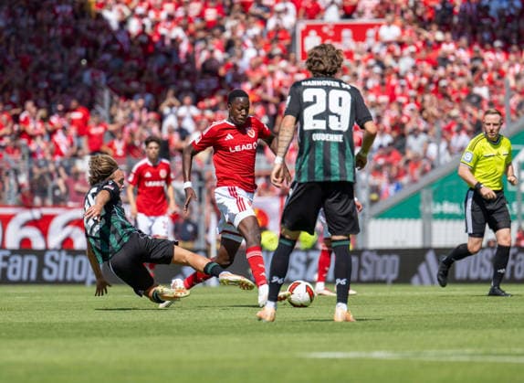Fussball, Herren, Saison 2026 2027, 2. Bundesliga (1. Spieltag), FC Energie Cottbus - Hannover 96, v.l. Lars Gindorf (Hannover), King Manu (Energie Cottbus), Kolja Oudenne (Hannover), 09.08. 2026, *** Soccer, Men s, 2026–2027 Season, 2. Bundesliga, Matchday 1, FC Energie Cottbus vs. Hannover 96, from left: Lars Gindorf (Hannover), King Manu (Energie Cottbus), Kolja Oudenne (Hannover), August 9, 2026, Copyright: xSebastianxRäppold MatthiasxKochx