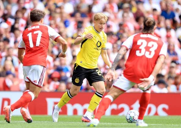 Daniel Svensson of Borussia Dortmund in action against Christos Tzolis (left) and Riccardo Calafioli of Arsenal Arsenal v Borussia Dortmund, Pre Season Friendly, Football, Emirates Stadium, London, UK - 09 Aug 2026London Emirates Stadium United Kingdom EDITORIAL USE ONLY No use with unauthorised audio, video, data, fixture lists, club league logos or live services. Online in-match use limited to 120 images, no video emulation. No use in betting, games or single club league player publications.  Copyright: xGeorgexTewkesbury Shutterstockx 17051143v