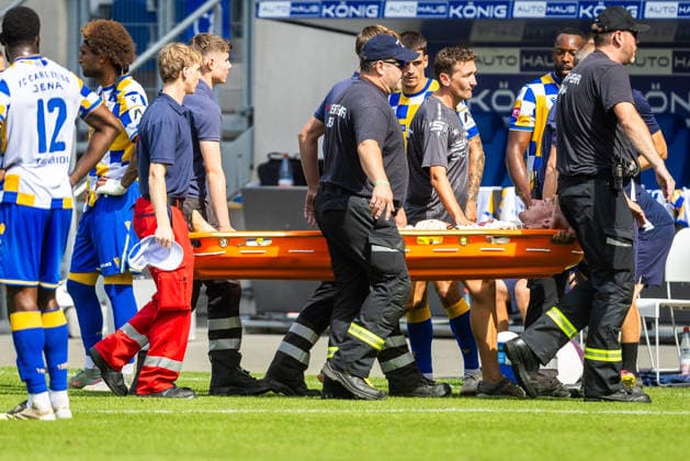 Jena , 090826, Fussball Regionalliga , FC Carl-Zeiss Jena - Rot Weiß Erfurt im Bild: Torwart Lorenz Otto (Erfurt) stößt mit Manasse Eshele (Jena) zusammen und muss verletzt vom Platz getragen werden *** Jena, August 26, 2009, Regional League Soccer, FC Carl Zeiss Jena vs. Rot-Weiß Erfurt: In the photo, Erfurt goalkeeper Lorenz Otto collides with Jena s Manasse Eshele and has to be carried off the field due to injury.