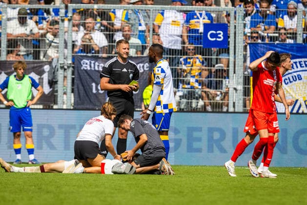 Jena , 090826, Fussball Regionalliga , FC Carl-Zeiss Jena - Rot Weiß Erfurt im Bild: Torwart Lorenz Otto (Erfurt) stößt mit Manasse Eshele (Jena) zusammen und muss verletzt vom Platz getragen werden *** Jena, August 26, 2009, Regional League Soccer, FC Carl Zeiss Jena vs. Rot-Weiß Erfurt: In the photo, Erfurt goalkeeper Lorenz Otto collides with Jena s Manasse Eshele and has to be carried off the field due to injury.