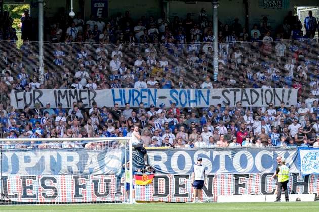 Die Fans vom F.C. Hansa Rostock zeigen in der Fankurve ein Banner, Spruchband mit der Aufschrift: Für immer Huren-Sohn-Stadion, Hurensohn, Fans, Ultras Publikum, Zuschauer, Stimmung, Atmosphäre, Stadion, Protest gegen Dietmar Hopp (Mitbegründer SAP, Mäzen, Investor, Förderer, Gesellschafter TSG 1899 Hoffenheim) und das nach ihm benannte Dietmar-Hopp-Stadion, Protestaktion, protestieren, Aktion, Action, 09.08.2026, Sinsheim (Deutschland), Fussball, 3. Liga, TSG 1899 Hoffenheim II - Hansa Rostock, DFB DFL REGULATIONS PROHIBIT ANY USE OF PHOTOGRAPHS AS IMAGE SEQUENCES AND OR QUASI-VIDEO. *** Fans of F.C. Hansa Rostock display a banner in the fan section that reads Forever Son of a Bitch Stadium, Son of a Bitch, fans, ultras, crowd, spectators, mood, atmosphere, stadium, protest against Dietmar Hopp, co-founder of SAP, patron, investor, sponsor, and shareholder of TSG 1899 Hoffenheim and the Dietmar Hopp Stadium named after him, protest action, protesting, action, August 9, 2026, Sinsheim, Germany, soccer, 3rd Division, TSG 1899 Hoffenheim II vs. Hansa Rostock, DFB and DFL regulations prohibit any use of photographs as image sequences and or quasi-video xozx