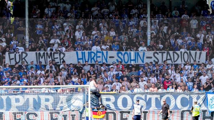 Die Fans vom F.C. Hansa Rostock zeigen in der Fankurve ein Banner, Spruchband mit der Aufschrift: Für immer Huren-Sohn-Stadion, Hurensohn, Fans, Ultras Publikum, Zuschauer, Stimmung, Atmosphäre, Stadion, Protest gegen Dietmar Hopp (Mitbegründer SAP, Mäzen, Investor, Förderer, Gesellschafter TSG 1899 Hoffenheim) und das nach ihm benannte Dietmar-Hopp-Stadion, Protestaktion, protestieren, Aktion, Action, 09.08.2026, Sinsheim (Deutschland), Fussball, 3. Liga, TSG 1899 Hoffenheim II - Hansa Rostock, DFB DFL REGULATIONS PROHIBIT ANY USE OF PHOTOGRAPHS AS IMAGE SEQUENCES AND OR QUASI-VIDEO. *** Fans of F.C. Hansa Rostock display a banner in the fan section that reads Forever Son of a Bitch Stadium, Son of a Bitch, fans, ultras, crowd, spectators, mood, atmosphere, stadium, protest against Dietmar Hopp, co-founder of SAP, patron, investor, sponsor, and shareholder of TSG 1899 Hoffenheim and the Dietmar Hopp Stadium named after him, protest action, protesting, action, August 9, 2026, Sinsheim, Germany, soccer, 3rd Division, TSG 1899 Hoffenheim II vs. Hansa Rostock, DFB and DFL regulations prohibit any use of photographs as image sequences and or quasi-video xozx