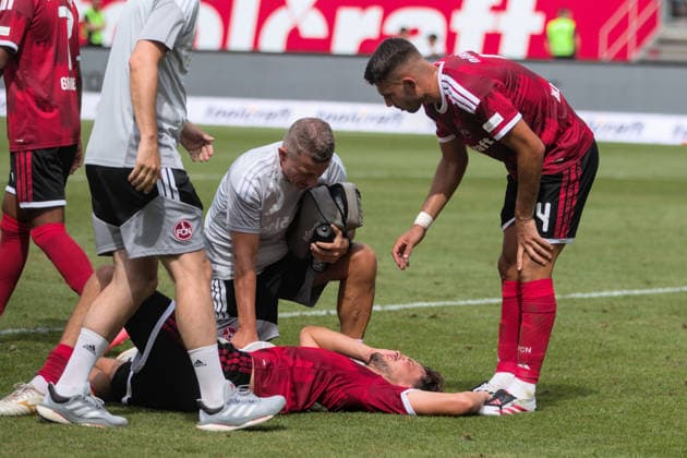 09.08.2026 Fußball Herren 2026 2027 2. Bundesliga 1. Spieltag 1. FC Nürnberg - SG Dynamo Dresden Max-Morlock-Stadion Nürnberg Fynn Otto (Nürnberg, 20, rot) liegt verletzt am Boden und wird behandelt. Alexios Kalogeropoulos (Nürnberg, 4, rot) erkundigt sich nach seinem Mitspieler. Nürnberg Bayern Deutschland *** August 9, 2026 Men s Soccer 2026–2027 2. Bundesliga Matchday 1 FC Nuremberg vs. SG Dynamo Dresden Max Morlock Stadium, Nuremberg Fynn Otto (Nuremberg), 20, is lying on the ground injured and receiving treatment Alexios Kalogeropoulos (Nuremberg), 4, in the red jersey, checks on his teammate Nuremberg Bavaria Germany