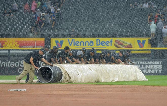 The Chicago White Sox ground crew roll out the tarp as the rain starts coming down at the end of the first inning against Cleveland Guardians at Rate Field in Chicago, IL on Sunday, August 9, 2026.  CHI20260809112 MARKxBLACK