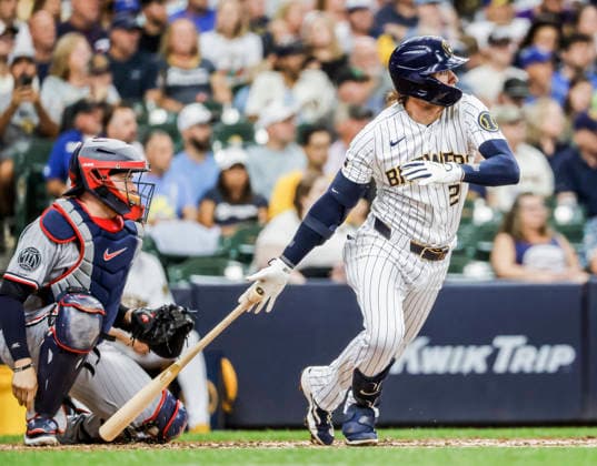 Milwaukee Brewers second baseman Brice Turang hits a single in front of Minnesota Twins catcher Victor Caratini in the fourth inning of the MLB, Baseball Herren, USA game between the Minnesota Twins and the Milwaukee Brewers at American Family Field in Milwaukee, Wisconsin on Sunday, August 9, 2026.  MIL20260809810 TANNENxMAURY