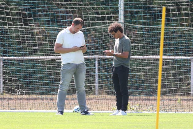 Training der Sportfreunde Siegen. Geschaeftsfuehrer (Geschäftsführer) Matthias Georg (SI) li. und Sportdirektor Nico Michaty (SI) schauen auf ihr Smartphone. Fussball Regionalliga West, Training, Sportfreunde Siegen, am 10.08.2026 in Mudersbach Deutschland. *** Training session for Sportfreunde Siegen: Managing Director Matthias Georg SI li and Sports Director Nico Michaty SI look at their smartphones. Regional League West soccer, training, Sportfreunde Siegen, on August 10, 2026, in Mudersbach, Germany