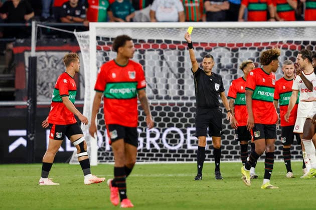 2026-08-11 NEC Nijmegen v Olympiacos - Champions League qualifying phase NIJMEGEN, NETHERLANDS - AUGUST 11: Referee Maurizio Mariani shows a yellow card to Kaj Sierhuis of NEC Nijmegen for is taking of this shirt after scoring (but the goal was disallowed) during the Champions League qualifying phase match between NEC Nijmegen and Olympiacos at Goffertstadion on August 11, 2026 in Nijmegen, Netherlands. Nijmegen Goffertstadion Netherlands Content not available for redistribution in The Netherlands directly or indirectly through any third parties. Copyright: xBenxGalx