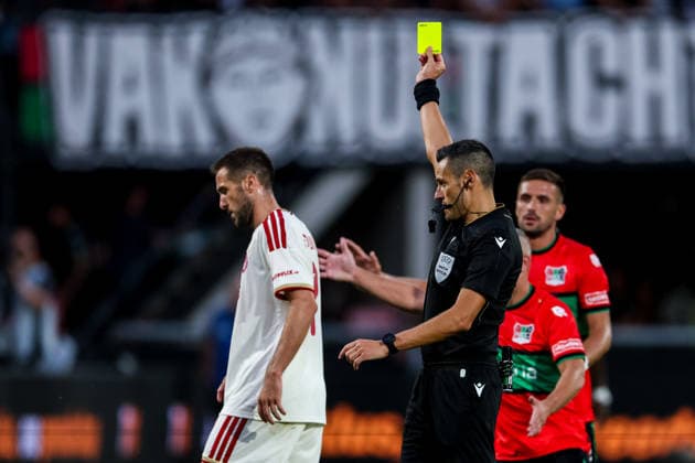 NIJMEGEN, NETHERLANDS - AUGUST 11: Kostas Fortounis of Olympiacos receives a yellow card from referee Maurizio Mariani during the UEFA Champions League 2026 27 third qualifying round second leg match between NEC Nijmegen and Olympiacos at the Goffertstadion on August 11, 2026 in Nijmegen, Netherlands.  Copyright: xRenexNijhuis MBxMediax