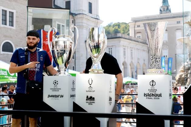 Fans pose for photos in the Super Cup fanzone next to the Super Cup, Champions League and Europa League trophies. Paris St Germain v Aston Villa, UEFA Super Cup Final, Football, Red Bull Arena, Salzburg, Austria - 12 Aug 2026Salzburg Red Bull Arena, Austria  Copyright: xJamesxMarsh Shutterstockx 17064758r