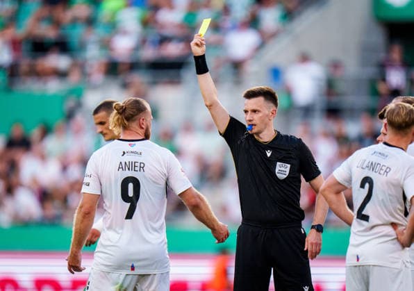 SOCCER - UEFA ECL, Rapid vs Paide VIENNA,AUSTRIA,12.AUG.26 - SOCCER - UEFA Conference League, qualification, SK Rapid Wien vs Paide Linnameeskond. Image shows referee Denys Shurman and Henri Anier (Paide). Keywords: yellow card.  GEPAxpictures xEdgarxEisner